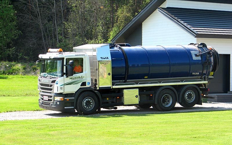 Jätehuolto Helistölä Oy:n imuauto lähdössä asiakkaalta